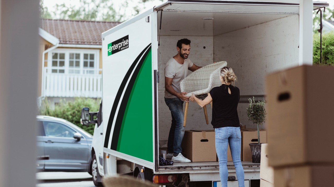 Couple unloading an Enterprise van for a house move