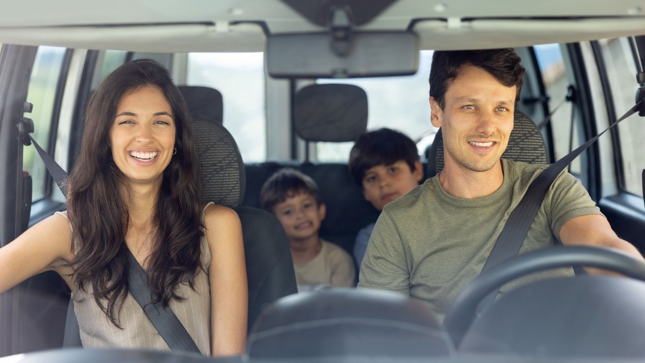 Happy Brazilian family going on a road trip in their car and smiling - lifestyle concepts