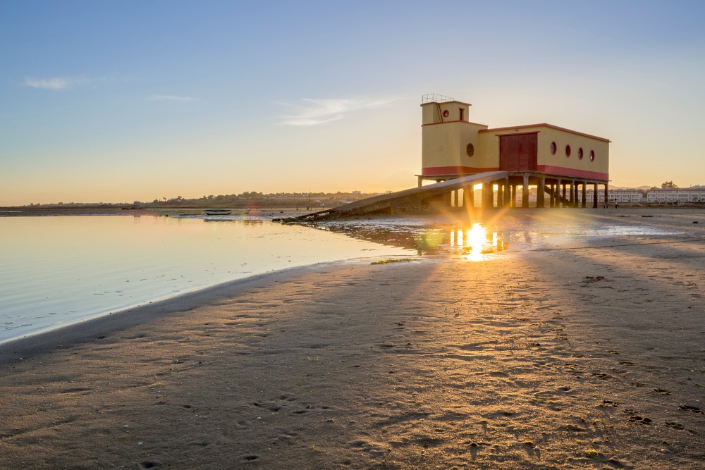 Sunset and historic life-guard building in the foreground, at Fuseta fishing town, Ria Formosa conservation park, Algarve. Portugal (Sunset and historic life-guard building in the foreground, at Fuseta fishing town, Ria Formosa conservation park, Alga