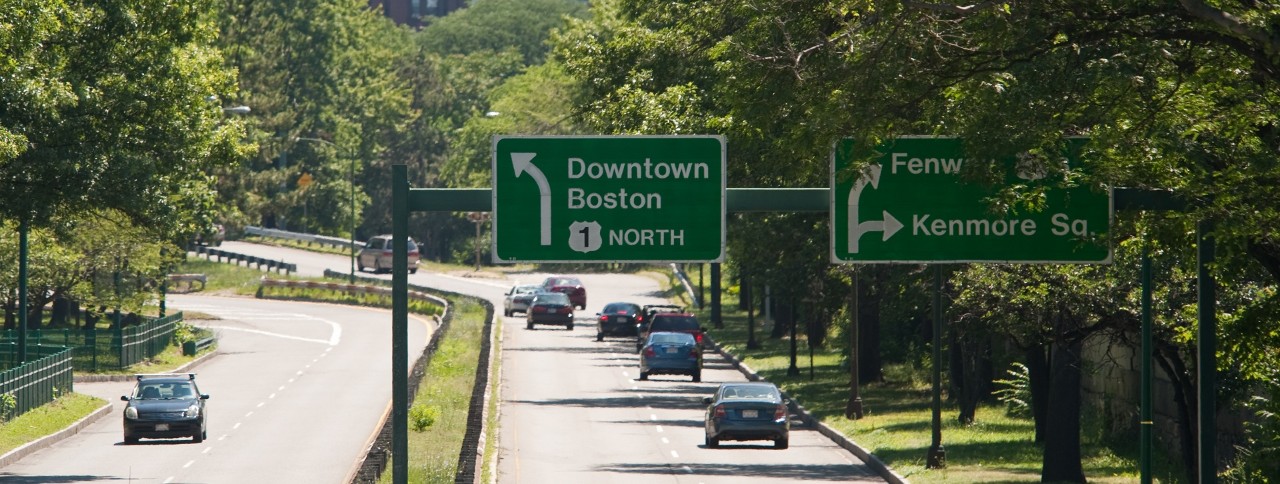 A common site for thousands of college bound students.  Traffic signs pointing the way to Boston and Kenmore Square on Storrow Drive