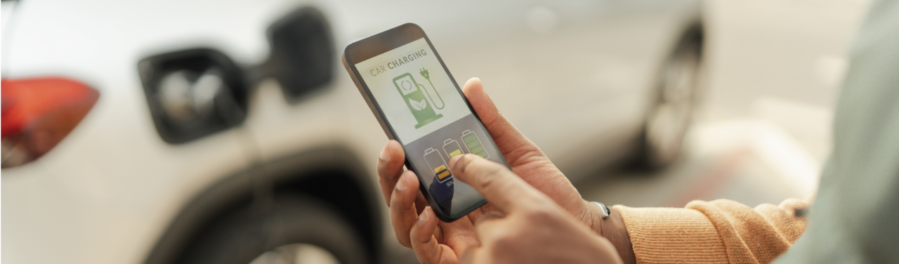 Close-up of men using application for charging his electric car.